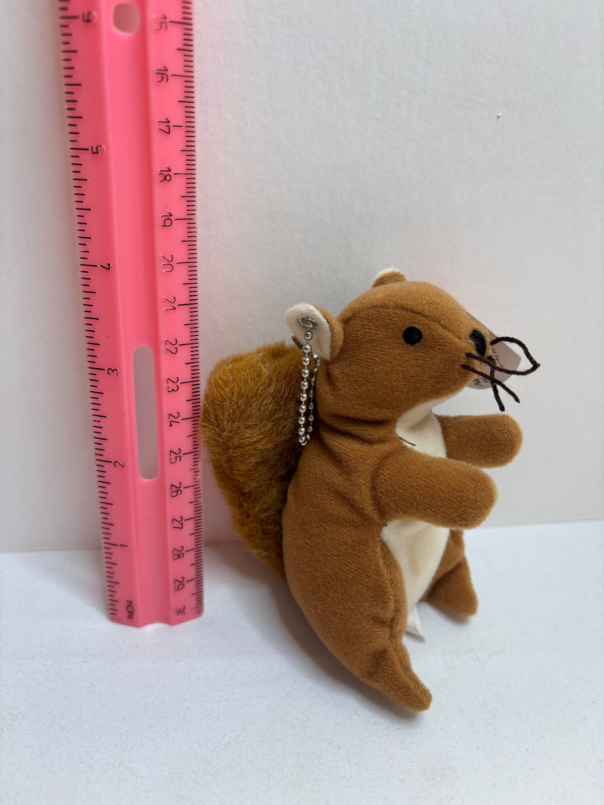Plush brown squirrel bag charm on a white background