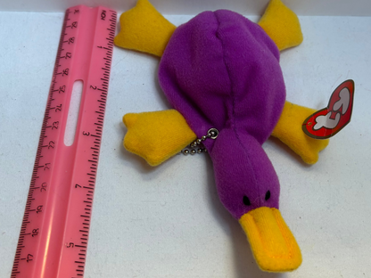 Purple and yellow plush platypus bag charm on a white background
