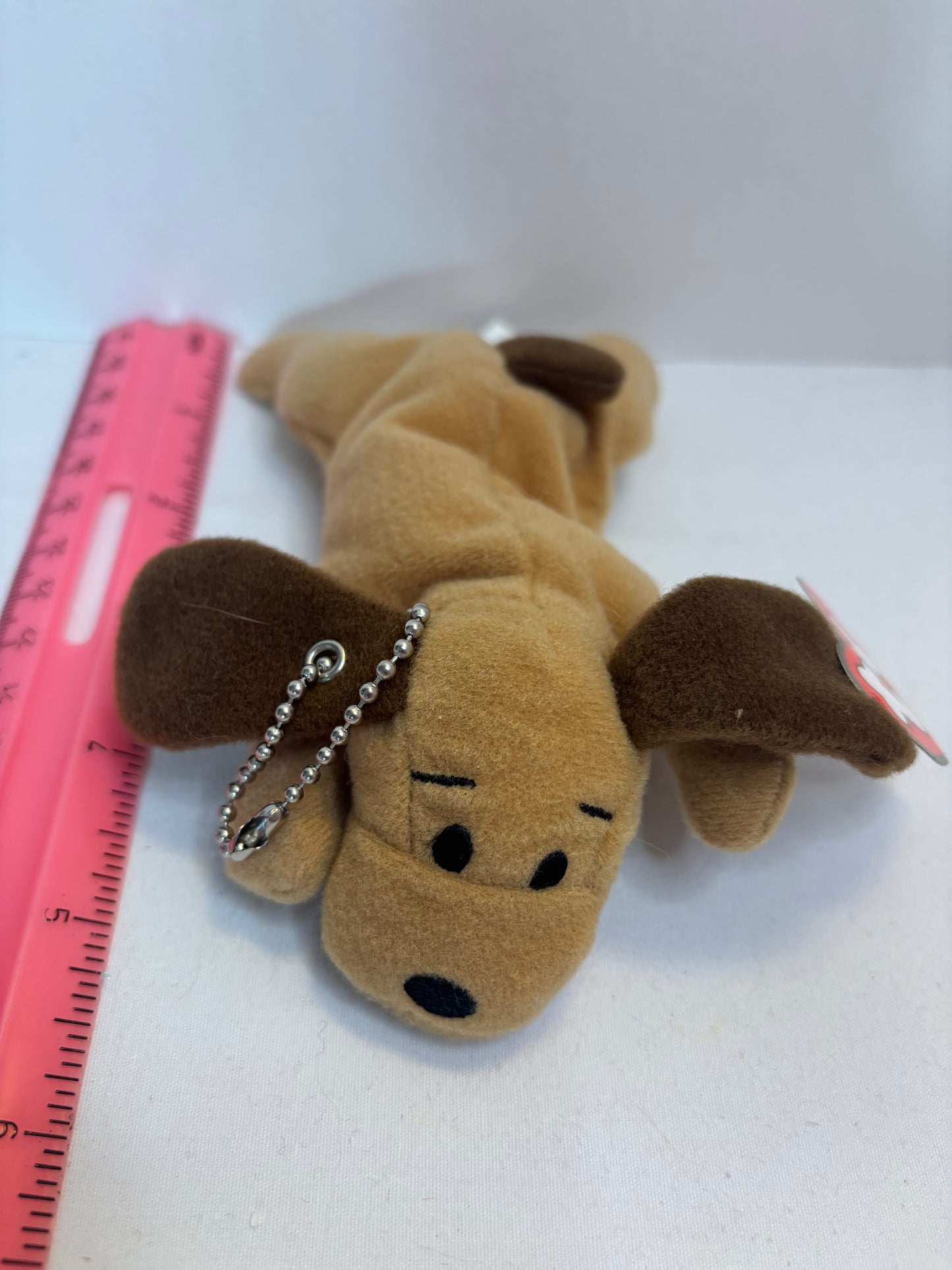 Plush brown dog bag charm on a white background