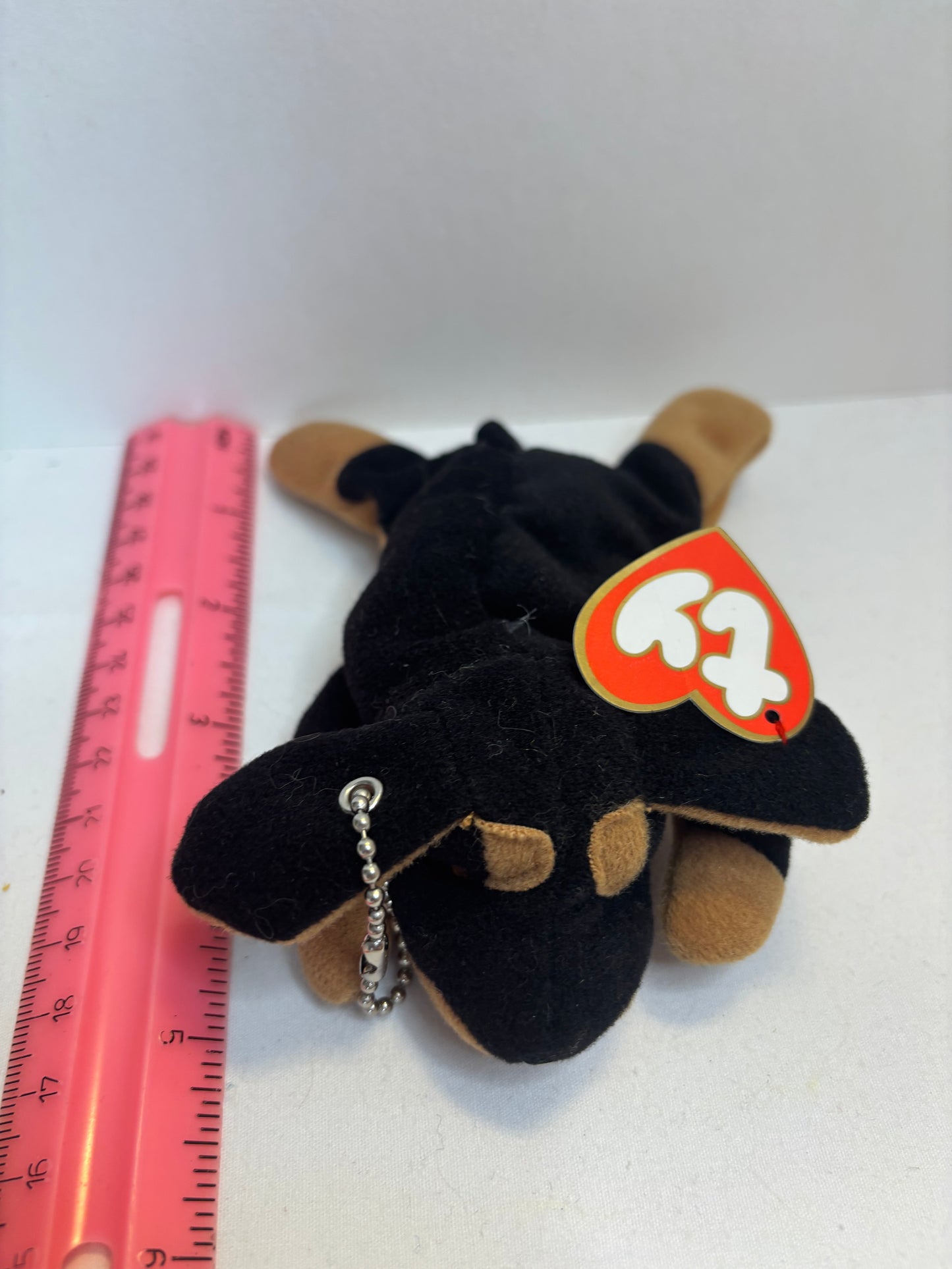 Black and brown plush dog bag charm on a white background