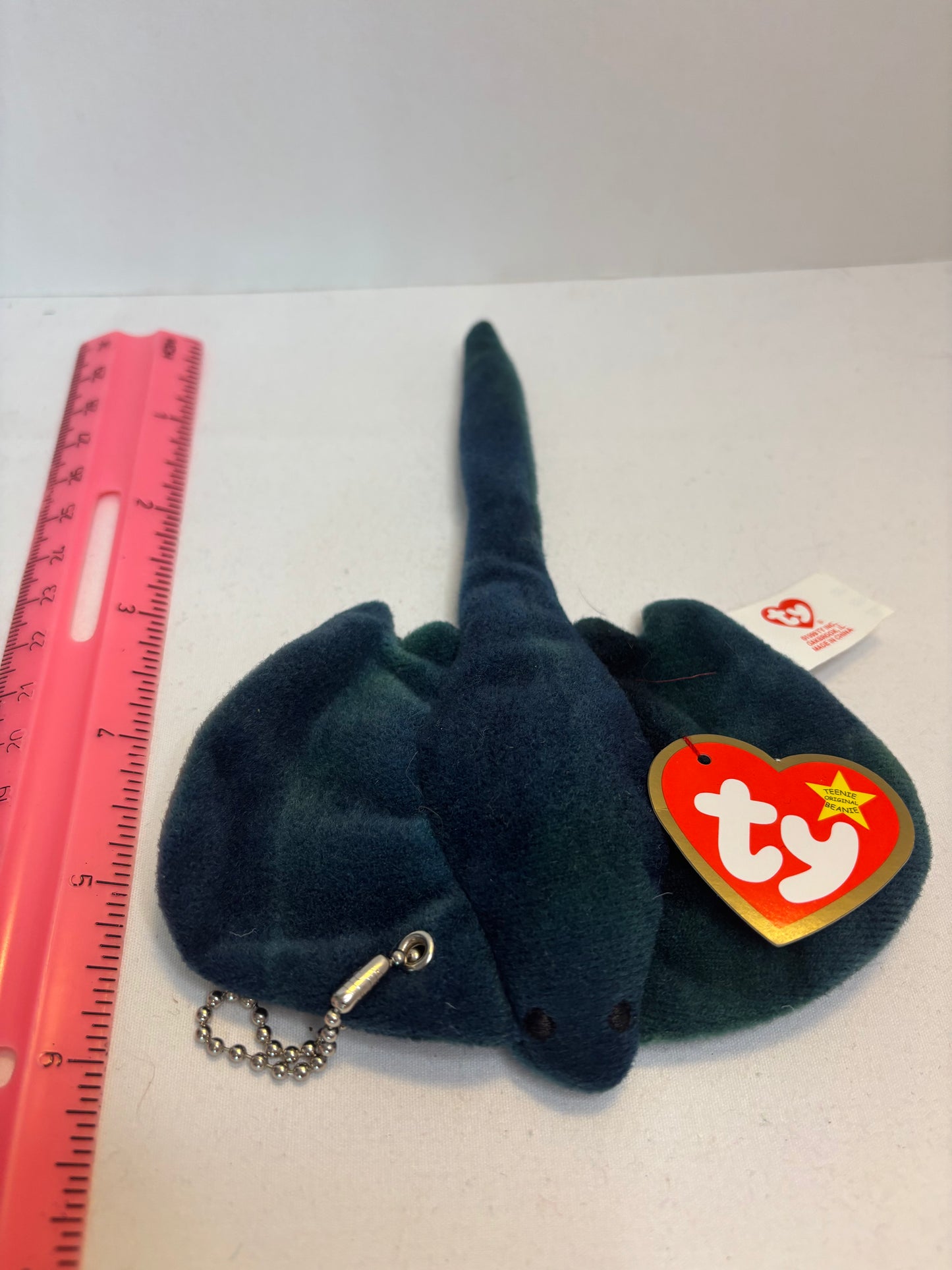 Dark blue stingray plush bag charm with a red Ty heart tag on a white background