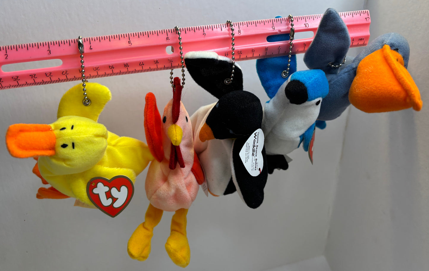 assorted colorful beanie baby plush toy bag charms on a white background