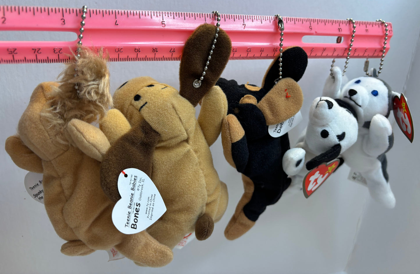 assorted colorful beanie baby plush toy bag charms on a white background