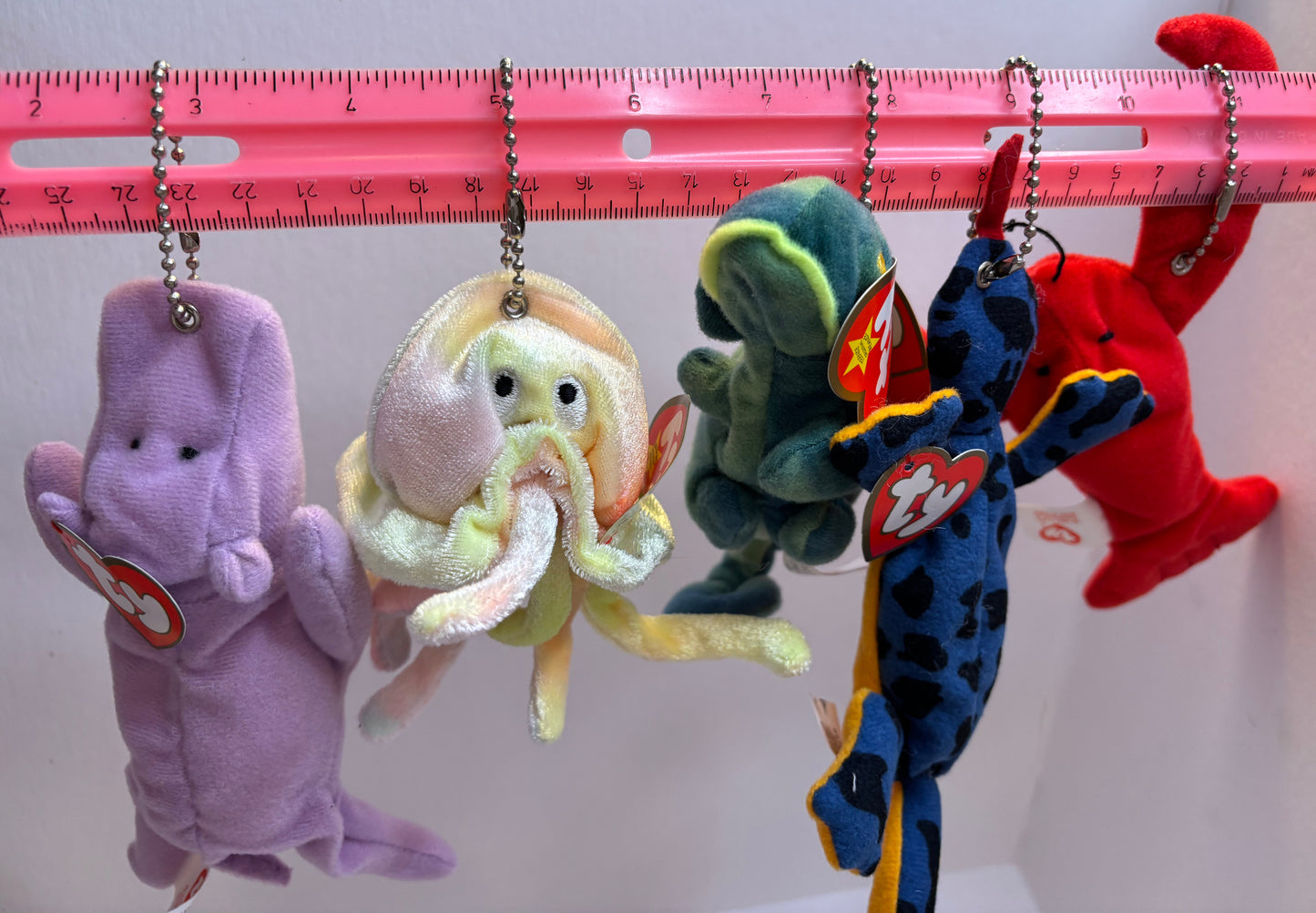 assorted colorful beanie baby plush toy bag charms on a white background