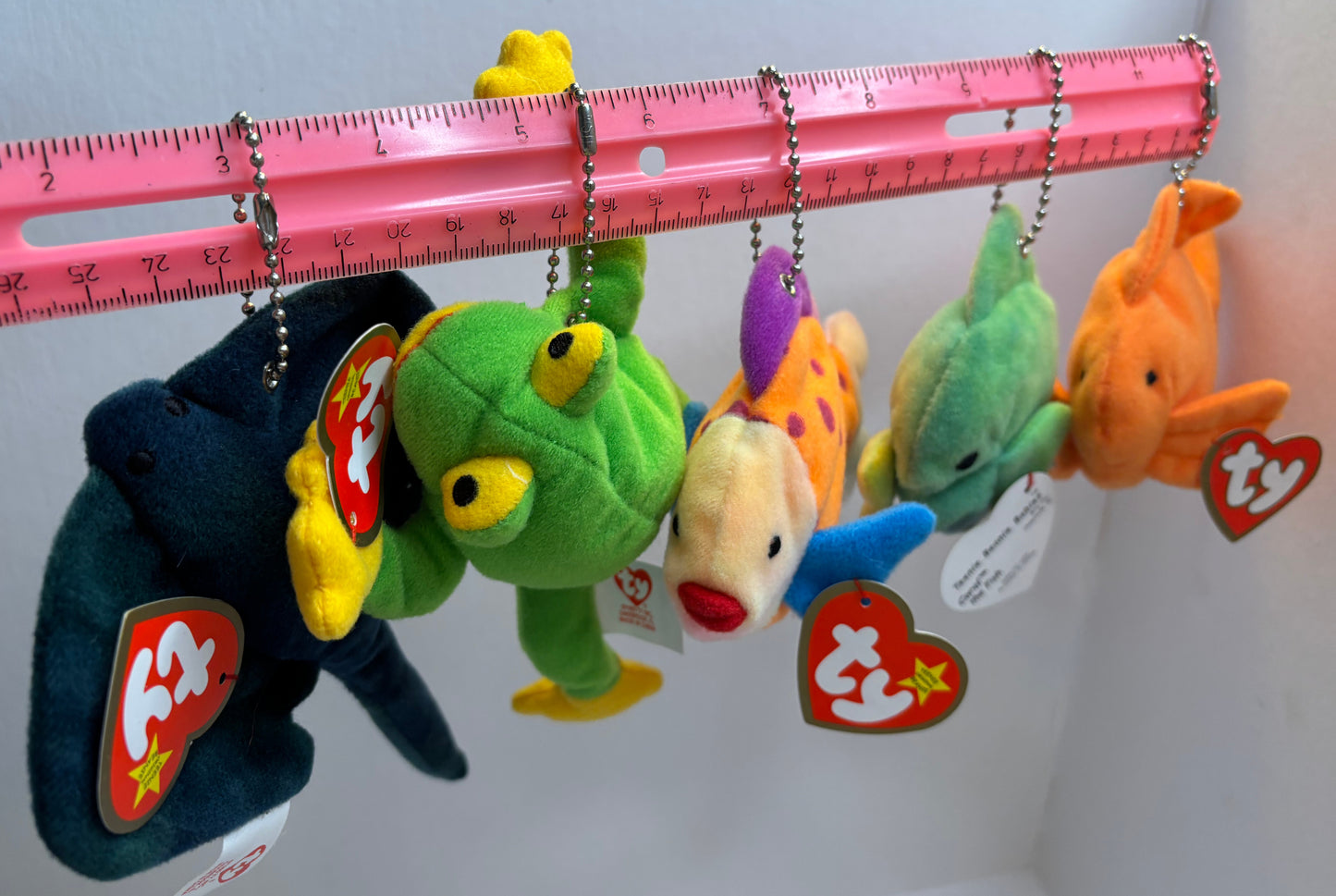 assorted colorful beanie baby plush toy bag charms on a white background