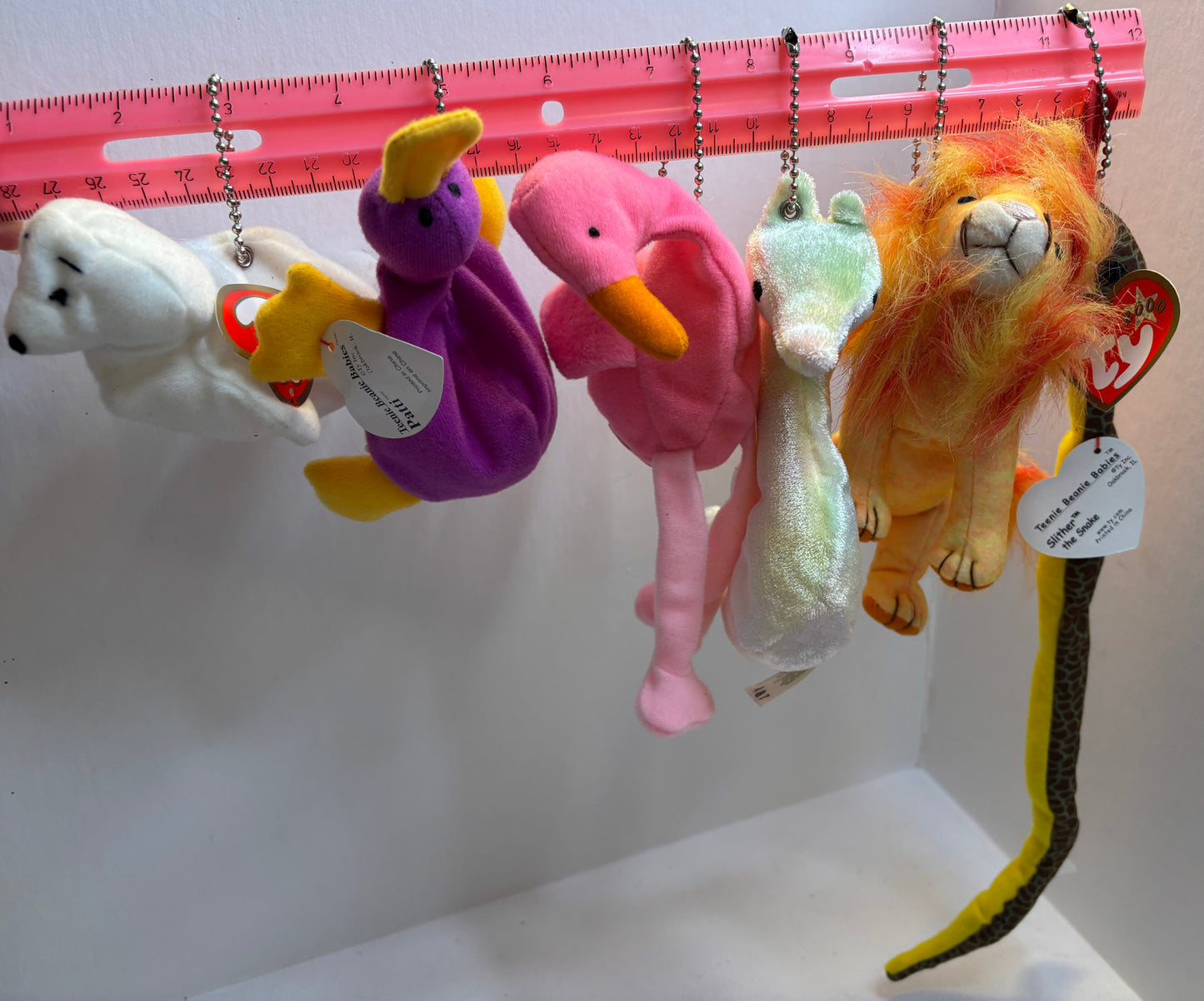 assorted colorful beanie baby plush toy bag charms on a white background