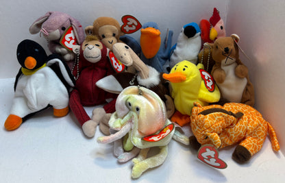 assorted colorful beanie baby plush toy bag charms in a pile on a white background