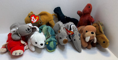 assorted colorful beanie baby plush toy bag charms in a pile on a white background