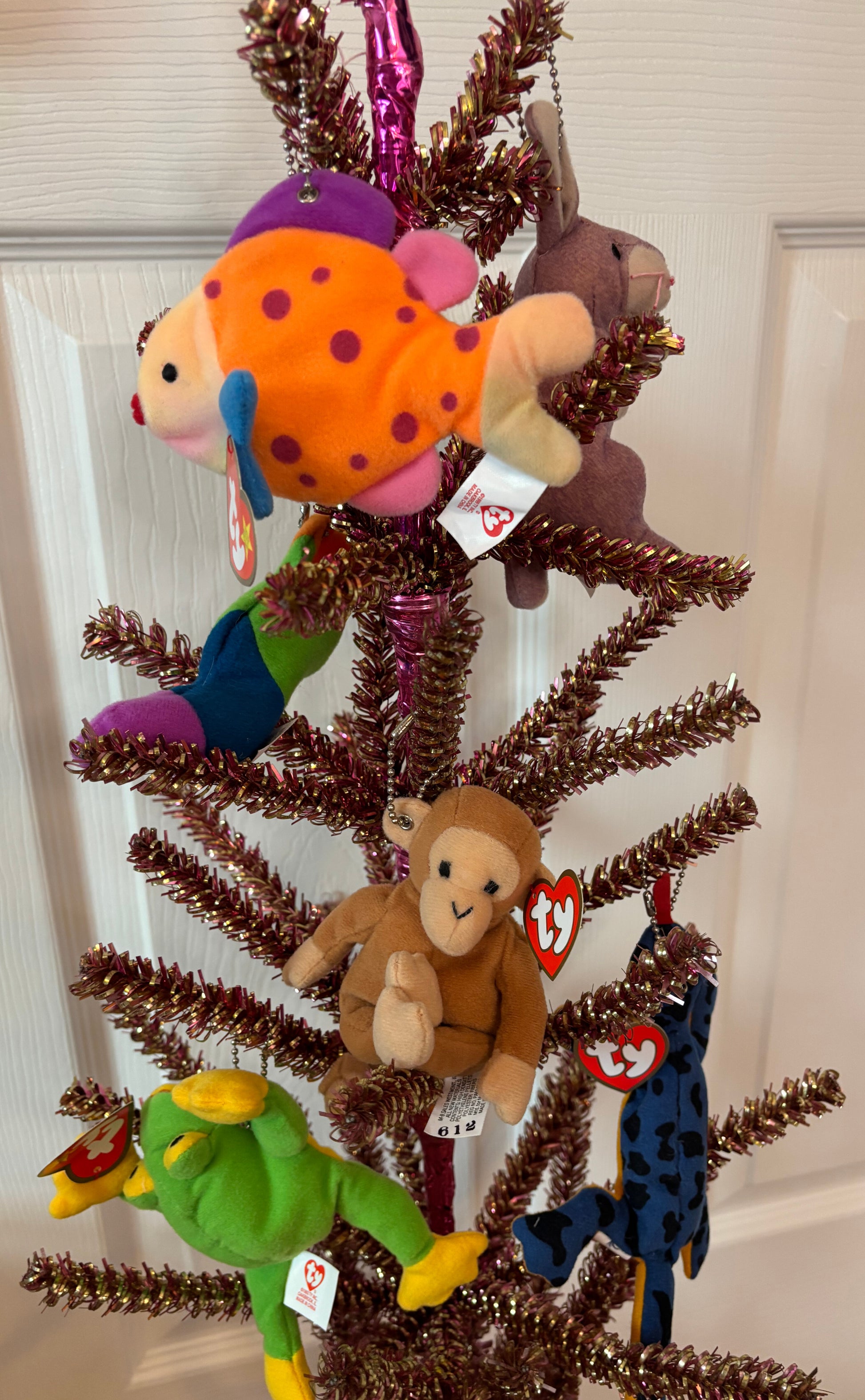 Decorative tree with TY plush bag charms including a fish, monkey, and others on a white background.
